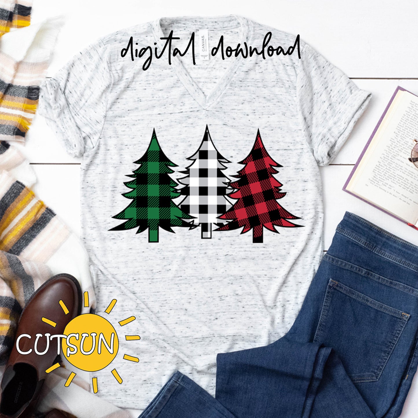 White t-shirt with plaid tree design, surrounded by jeans, shoes, and a scarf on a wooden surface.