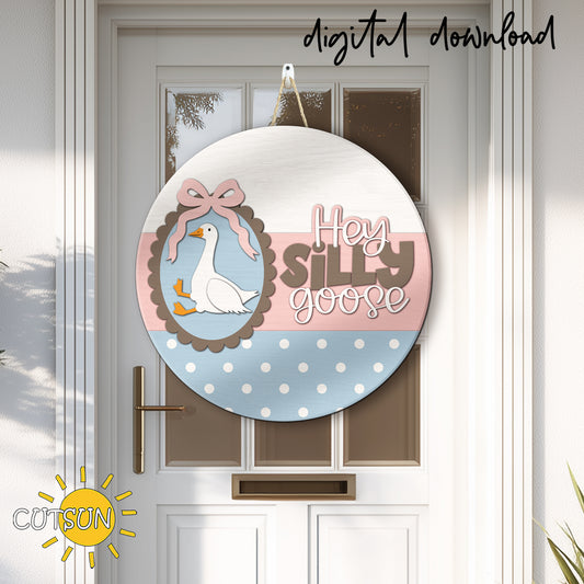 Layered round wooden door hanger with a cute goose, bow detail and “Hey Silly Goose” text in pastel farmhouse style