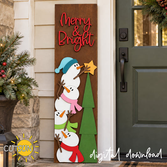 Tall wooden Merry & Bright porch leaner beside a front door, featuring four snowmen in colorful scarves next to a green Christmas tree with a gold star.