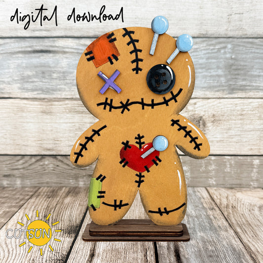 Layered Halloween voodoo doll shelf sitter SVG featuring a stitched doll character with button eye, pins, patch details, and freestanding display base for laser cutting.