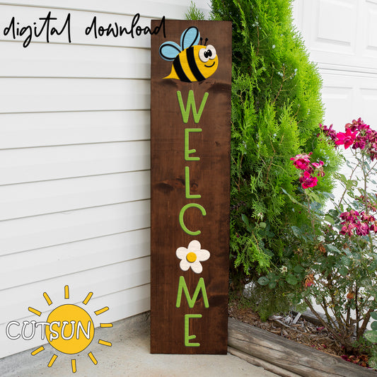 Wooden sign with a bee and 'Welcome' text, placed outdoors next to a house.