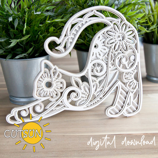 Decorative letter 'A' with intricate patterns on a wooden surface, surrounded by potted plants.