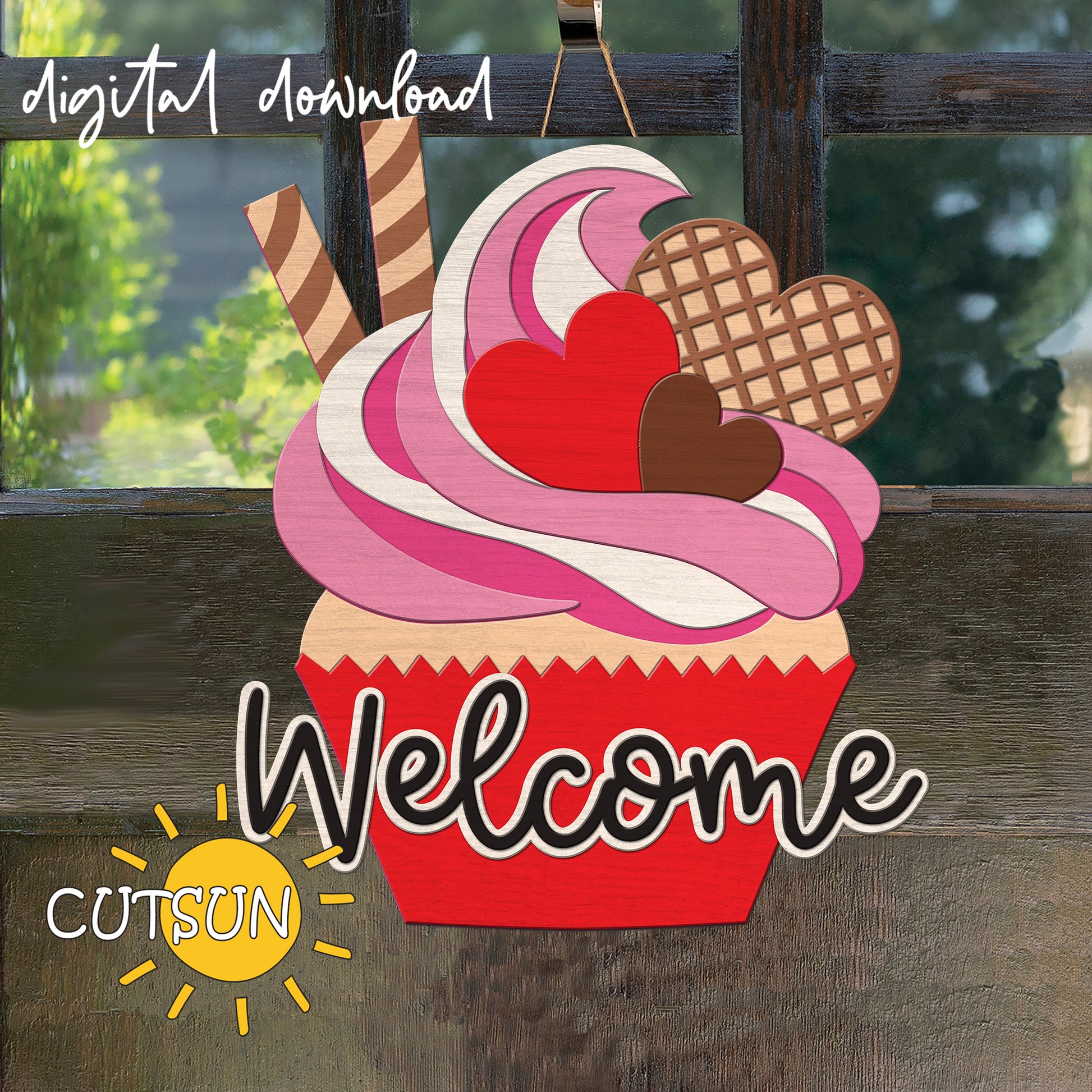 Decorative sign shaped like a cupcake with pink frosting, heart-shaped cookies, and the word 'Welcome' on a wooden background.