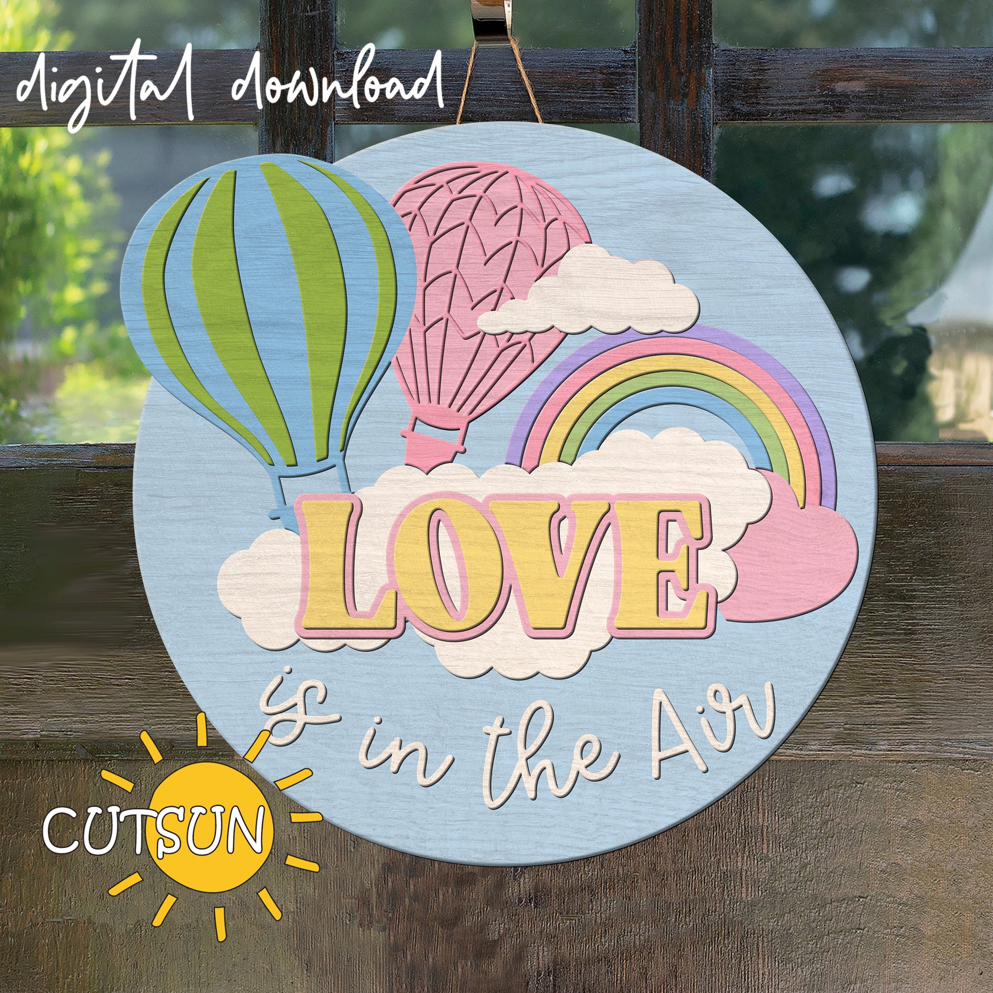 Decorative sign with hot air balloons, rainbow, and 'LOVE is in the Air' text on a wooden background.