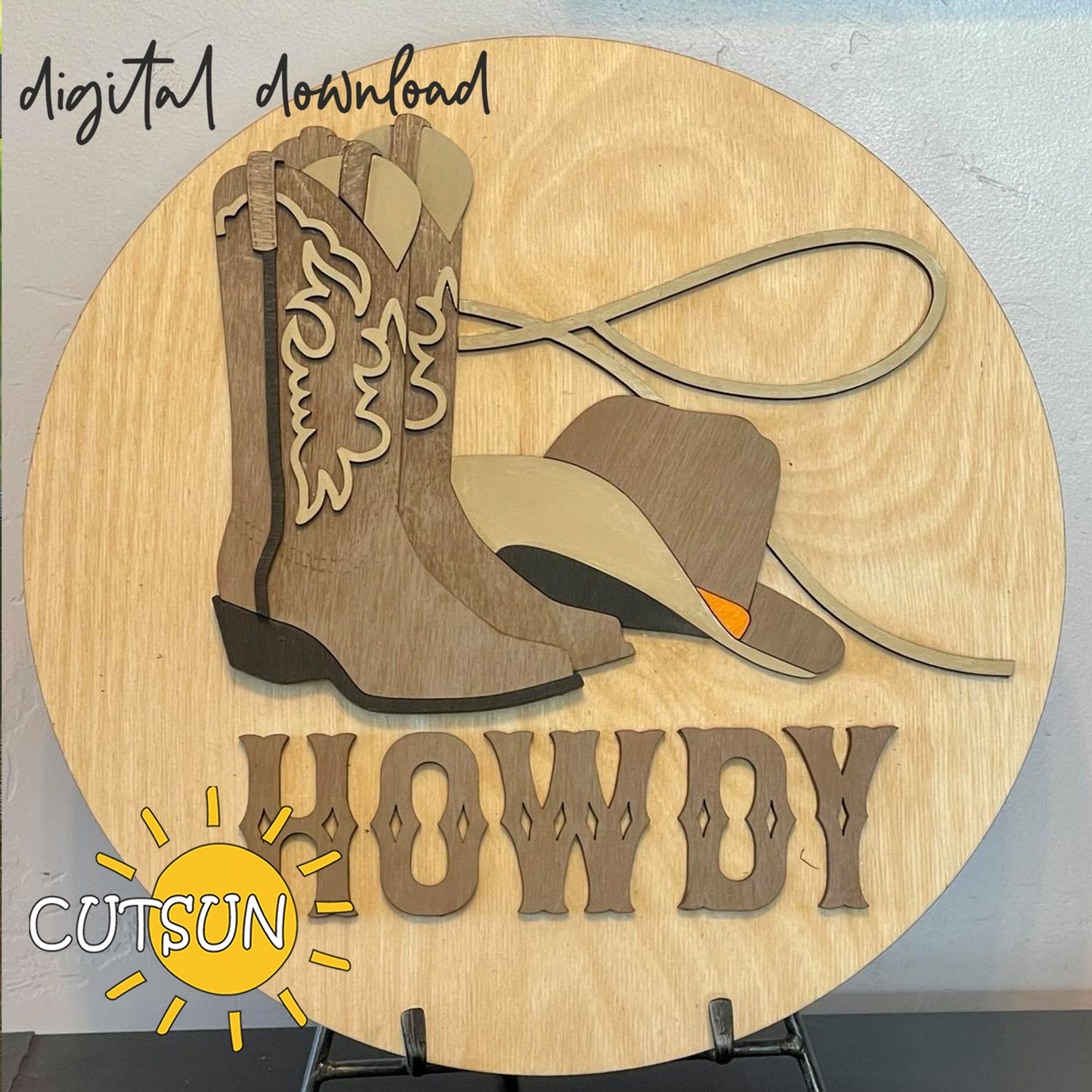Digital download for a door hanger laser cut file featuring a cowboy boot,a cowboy hat, a lasso and the text Howdy