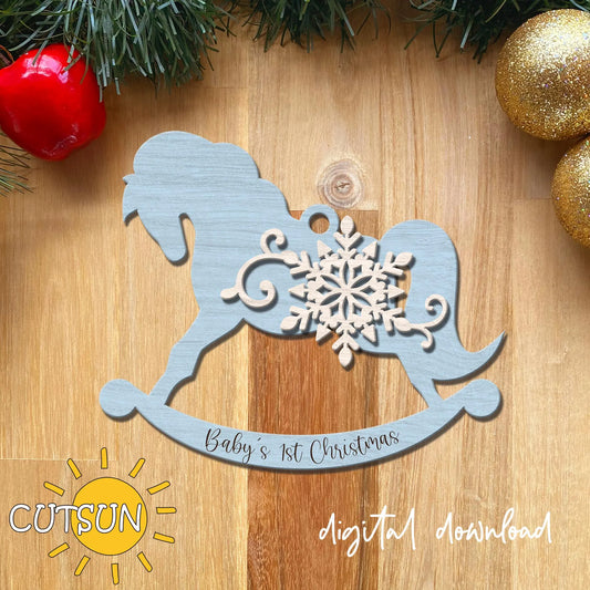 Decorative cutout of a baby's first Christmas design with a snowflake on a wooden surface, featuring the CUTSUN brand.