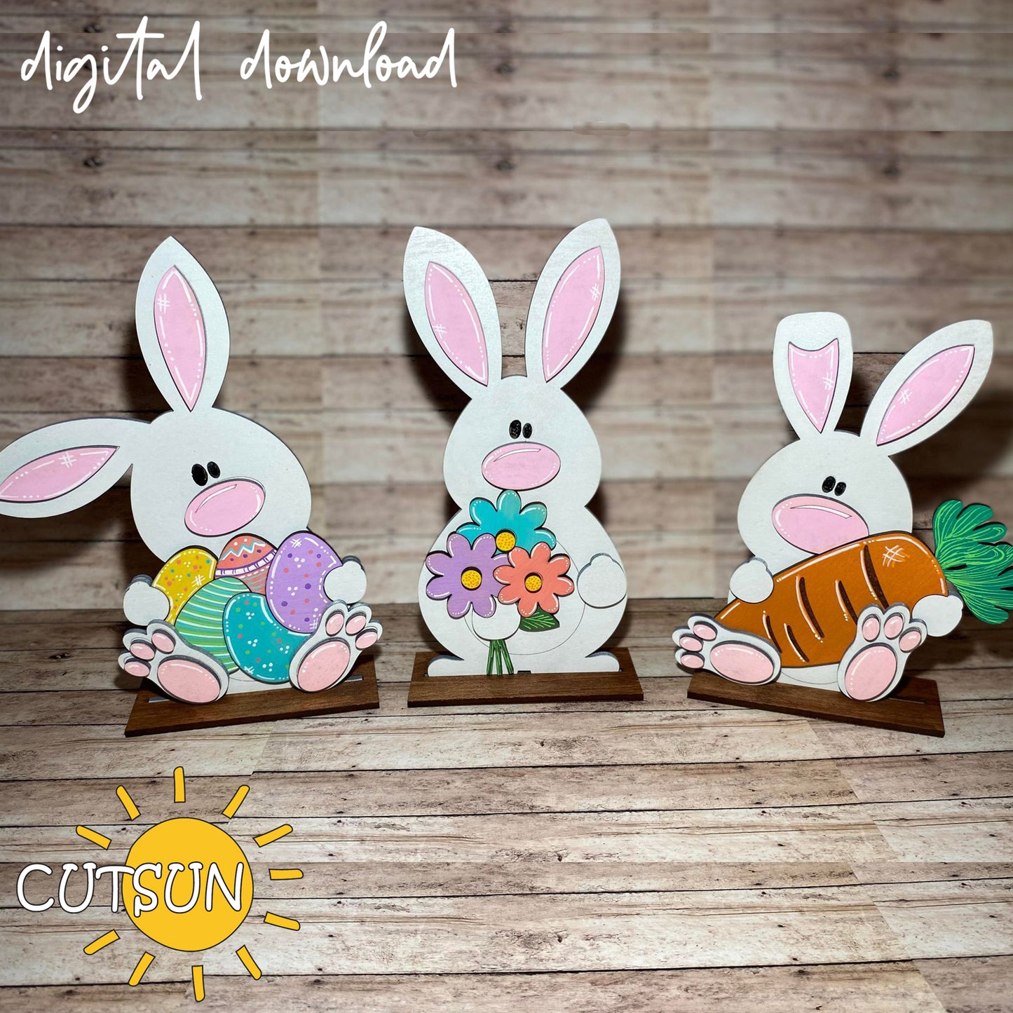 Three paper bunny cutouts on a wooden surface with 'CUTSUN' branding.