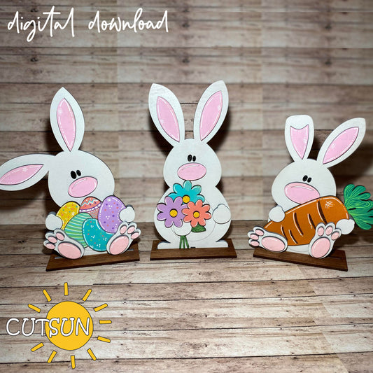 Three paper bunny cutouts on a wooden surface with 'CUTSUN' branding.