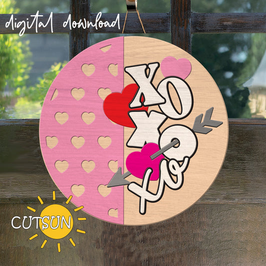 Circular wooden cutout with 'XO' and heart designs on a pink and beige background, with 'CUTSUN' logo.